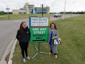 Shay NcNabb, left, University of Regina nursing student, and her mother Kim McKay-McNabb stand by the new sign signalling a change in the one-way traffic around the First Nations University of Canada.