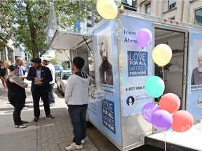 Imam Zeeshan Ahmed, right, speaks with Alyson Ford at the  #MobileMuslims exhibit in Regina on Tuesday.  The exhibits goals is to spread the true, peaceful teaching of Islam and remove misconceptions about the religion by stopping at various cities along the way.  TROY FLEECE / Regina Leader-Post