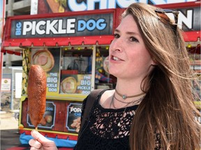 Leader-Post reporter Alex Johnson with a Big Pickle Dog from Chicky's Chicken at the Queen City Exhibition.