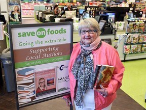 Byrna Barclay inside Save On Foods, beside promotional signage for book signings. Barclay has organized a weekly book sale and signing with other Regina writers.