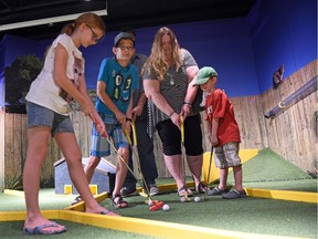 (Left to right) Makaila Lawrence from Saskatoon, along with brother Nick , mom Candice and brother Alex enjoy the mini golf station at the Saskatchewan Science Centre Backyard Adventures exhibit.  Dad, Trent Lawrence, is hidden from view, but was on hand for the family activity.