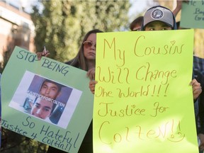 Family, friends and supporters hold signs during a rally for homicide victim Colten Boushie outside provincial court in North Battleford on Aug. 18.