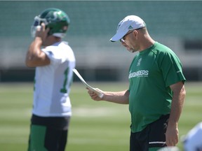 Saskatchewan Roughriders special-teams co-ordinator Craig Dickenson, left, reviews a chart at practice earlier this week.