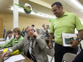 Premier Brad Wall, seen here working the phones duirng a 2009 byelection, has a big call to make if an offer is made to buy SaskTel.