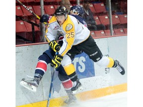 Duncan Campbell of the Brandon Wheat Kings checks Liam Schioler of the Regina Pats into the boards during WHL pre-season action at Westman Place on Friday evening.