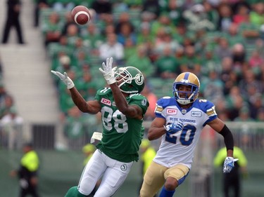 Caleb Holley #88 of the Saskatchewan Roughriders completes while Johnny Adams #20 of the Winnipeg Blue Bombers looks on during the Labour Day Classic held at Mosaic Stadium in Regina, Sask. on Sunday Sept. 4, 2016.