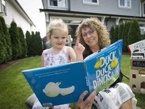 Coquitlam B.C. August 29, 2016    Taking in the magic-- 3 year old Emmeline Birch (left) settles in with the Vancouver Sun's Valerie Casselton having fun with author Kallie George's "Duck Duck Dinosaur" "for upcoming Raise-A-Reader feature story.    Mark van Manen/ PNG Staff photographer   see  Valerie Casselton   Province /Vancouver Sun/ Feature /stories  and Web.  00044730A [PNG Merlin Archive]