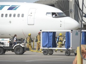 EMS and Regina Fire and Protective Services approach a Westjet flight at the Regina International Airport in Regina, Sask. on Saturday Sept. 3, 2016. Reports suggested there was smoke in the flight deck.