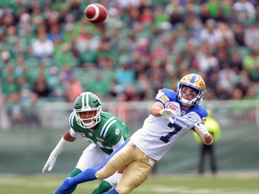 Justin Cox #31 of the Saskatchewan Roughriders looks on as Weston Dressler #7 of the Winnipeg Blue Bombers completes a pass during the Labour Day Classic held at Mosaic Stadium in Regina, Sask. on Sunday Sept. 4, 2016.