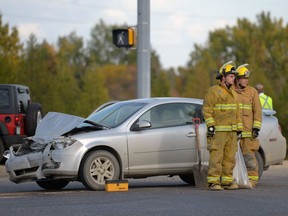 Regina Fire and Protective Services members clean-up after a car and a school bus collided at a Wascana Parkway exit to the Trans-Canada highway in Regina, Sask. on Wednesday Sept. 21, 2016. MICHAEL BELL