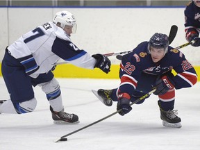 Regina Pats forward Rykr Cole (22) is pressured by Saskatoon Blades forward Michael Farren (27) in WHL pre-season action at the Co-operators Centre on Saturday.