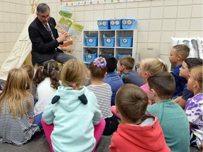 Education Minister Don Morgan read a story to Sienna Borland's grade 1 and 2 class at W.F. Ready School in Regina.