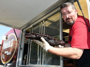 Mike Underhill, manager of the Prairie Smoke & Spice food truck, holds a beef brisket.
