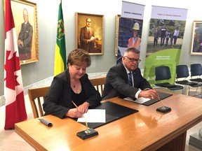 Saskatchewan's Government Relations minister, Donna Harpauer, and federal Public Safety Minister Ralph Goodale sign the Saskatchewan portion of an infrastructure agreement that Goodale described as the largest in Canadian history.