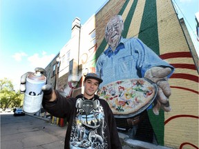 Artist Danny Fernandez with his mural of Robert Gardikiotis on the side of the Copper Kettle restaurant in downtown Regina.