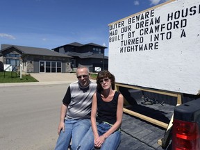 Brad and Sharon Lenz with their sign in front of a Crawford show home.