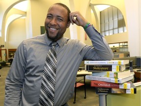 U of R Students' Union president Jermain McKenzie poses with some of the textbooks on reserve in the library.