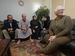 Barb Ryan, right, sits with the Al Moulia and Al Hussein families at the Al Moulia home in Regina.