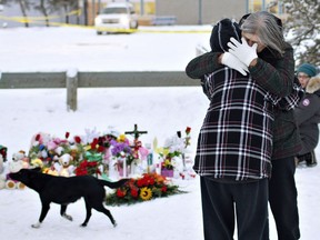 Residents console each other at the memorial near the La Loche Community School in January after a shooting left four people dead.