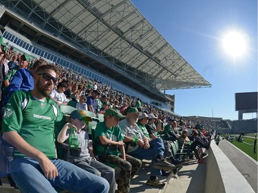 Brennan Craig, left, sits with his sons Simon and Jude at the new Mosaic Stadium test event featuring the University of Regina Rams vs. the University of Saskatchewan Huskies in Regina, Sask. on Saturday Oct. 1, 2016.