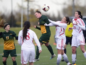 Kayla McDonald (3) of the University of Regina Cougars heads the ball toward the net in an unsuccessful goal attempt while University of Winnipeg Wesmen player Gelsomina Vanderhooft (5) guards her in Sunday's game.