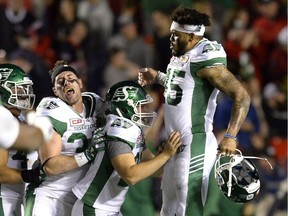 Saskatchewan Roughriders' Kacy Rodgers, 45, and Bryn Roy, 37, celebrate with kicker Tyler Crapigna, second from right, after his game-winning field goal against the Ottawa Redblacks on Friday.