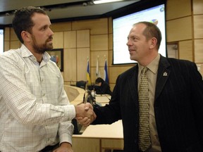 Shawn Fraser (L) a candidate for city councillor in ward three is congratulated by Wade Murray a city councillor for ward six at Regina City Hall on October 24, 2012.