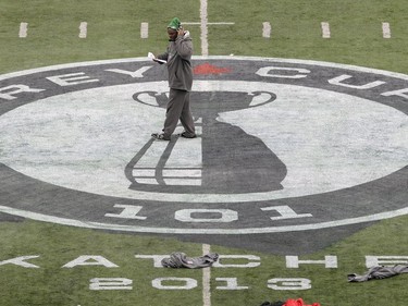 Rider assistant coach Richie Hall across the Grey Cup 101 logo freshly painted on the Taylor field turf during practice at Mosaic Stadium in Regina on Friday 11 82013.