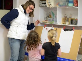 Colleen Schmidt, president of the Cathedral Area Cooperative Daycare, paints with Chloe Silva and Aubrey Avram at the Whitmore Park Childcare Cooperative.