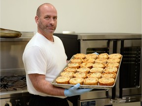 Chef Malcolm Craig holds up a tray of homemade meat pies.
