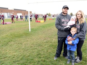Johnson Wildcats head football coach Jason Janssen is shown with his wife, Laurissa, and two children — Emmitt (four years) and Elliette (seven weeks) — during a practice at F.W. Johnson Collegiate.