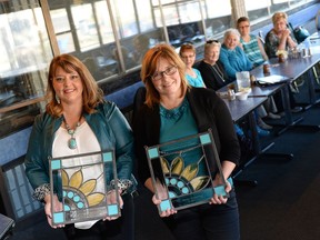 Joanne Gasper, left, and Wendy Sutherland hold their Peggy Truscott Award of Hope for their work raising money and awareness for ovarian cancer.