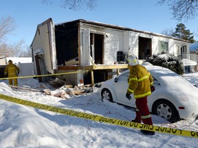 Regina firefighters do a safety audit at 152 Cooper Crescent in Regina on February 25, 2015 after a explosion one night earlier blew the west wall off the house and sent three people to hospital.