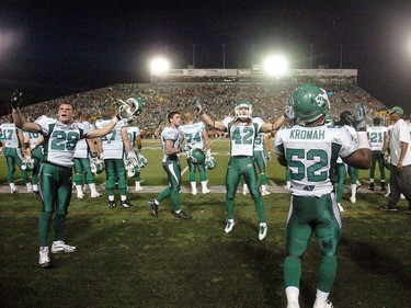 Saskatchewan Roughriders' players Craig Butler (L) #28 and Graig Newman (C) #42 cheer on the crowd in the final minutes of the fourth quarter during pre-season action between the Calgary Stampeders and the Saskatchewan Roughriders at Mosaic Stadium in Regina on June 22, 2012.  The Stampeders went on to win 33-31.