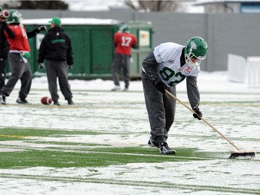 Saskatchewan Roughriders slotback Jason Clermont (#82) went from team hero last sunday scoring the overtime game winning touchdown to send the team to the West final against Calgary, to being just one of the guys sweeping snow off the field during practice Wednesday at Mosaic Stadium in Regina November 17, 2010.