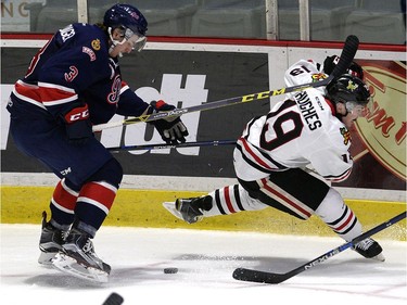 Pats James Hilsendager takes Portland's Ryan Hughes off the puck during WHL action between the Regina Pats and the Portland Winterhawks at the Brandt Centre in Regina Wednesday night.