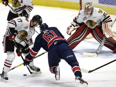 Portland's Alex Overhardt checks Pats Filip Ahl in front of Portland goal tender Michael Bullion during WHL action between the Regina Pats and the Portland Winterhawks at the Brandt Centre in Regina Wednesday night.