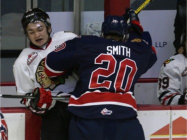 Portland's Evan Weinger is taken into the boards by Pats Luc Smith during WHL action between the Regina Pats and the Portland Winterhawks at the Brandt Centre in Regina Wednesday night.