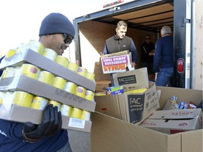 Allan Pulga and other Farm Credit Canada employees unpack a tractor load food donations to the Regina Food Bank during Drive Away Hunger on Thursday.