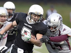 The Thom Trojans' Josh Daly, 5, tries to fight off a tackle from the Johnson Wildcats' Jayson Martin during Regina Intercollegiate Football League action Thursday at Leibel Field.