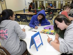 Rabneet Gahir, Sobia Fatma and Clerissa Downs work on posters for their fundraiser carnival. Proceeds will help fund a monument for the Regina Indian Industrial School cemetery.