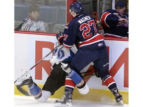 Austin Wagner of the Regina Pats takes Kaeden Taphorn of the Kootenay Ice into the boards during WHL action at the Brandt Centre on Friday.