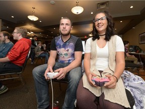 Sean MacGillivray, center, and Catherina Hofer, right, play at the Queen City Smash Bros tournament held at the Sandman Hotel in Regina on Oct. 15, 2016.
