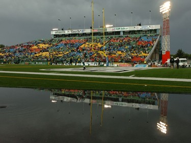 Roughrdiers fullback Neal Hughes warms up as a massive puddle drains on the sidelines before the Riders' 41-33 win over the Alouettes at Mosaic Stadium Saturday.