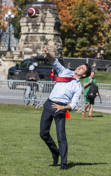 The Saskatchewan Roughriders practiced on Parliament Hill in Ottawa on Tuesday October 11, 2016. Prime Minister Justin Trudeau throws a pass. Errol McGihon/Postmedia ORG XMIT: POS1610111501471899