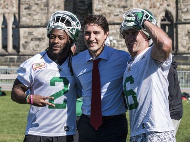 The Saskatchewan Roughriders practiced on Parliament Hill in Ottawa on Tuesday October 11, 2016. Prime Minister Justin Trudeau has his photo taken with RB Curtis Steele (#2) and WR Rob Bagg. Errol McGihon/Postmedia ORG XMIT: POS1610111501421894