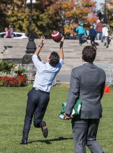 The Saskatchewan Roughriders practiced on Parliament Hill in Ottawa on Tuesday October 11, 2016. Prime Minister Justin Trudeau attempts an over the shoulder catch (he dropped the ball). Errol McGihon/Postmedia ORG XMIT: POS1610111501451897