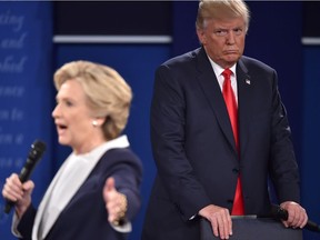 TOPSHOT - Republican presidential candidate Donald Trump listens to Democratic presidential candidate Hillary Clinton during the second presidential debate at Washington University in St. Louis, Missouri on October 9, 2016. /