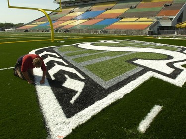 Team Rochon's James Ferguson works on the Rider Logo in the north endzone.