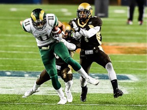 University of Regina Rams receiver Andrew Bennett fights off two University of Manitoba Bisons defenders during a Canada West football game Saturday in Winnipeg.